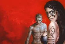 A dark-haired woman with facial markings stands in front of a pale, fanged man against a red background.