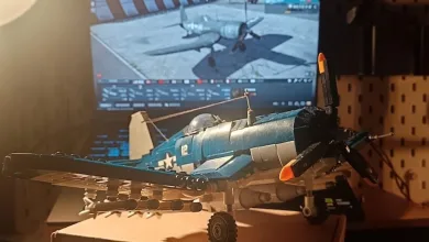 A blue Corsair model sits in front of a monitor showing War Thunder.