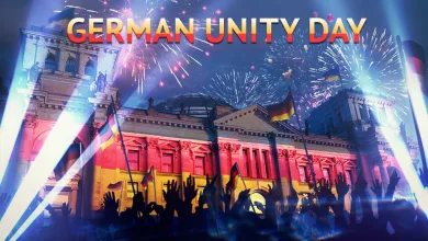 German Unity Day celebration scene with German flags, fireworks, a crowd, and a brightly lit historic building