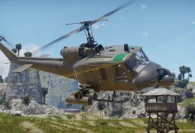 An armed UH-1C helicopter flies above a tropical landscape in War Thunder.