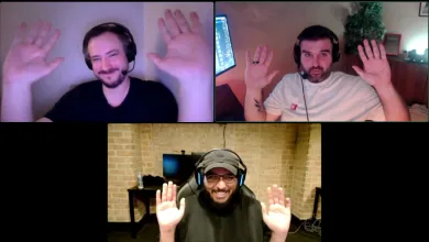 Three men wearing headsets raise their hands during a video call.